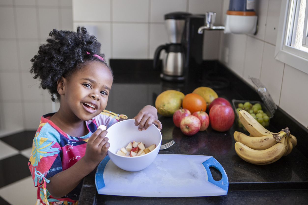 little girl eating apple slices.