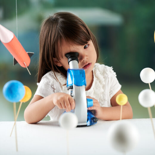little girl using microscope.